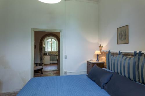a bedroom with a blue bed and a hallway at Agriturismo Spazzavento in Palazzone