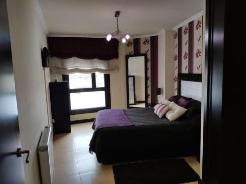 um quarto com uma cama e uma grande janela em Precioso Piso+Garaje Zona Sanxenxo Grove Portovono em Pontevedra