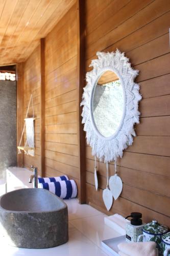 a bathroom with a sink and a mirror on the wall at Green Village Jungle Resort in Nusa Penida
