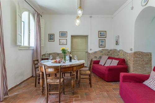 a living room with a table and a red couch at Agriturismo Spazzavento in Palazzone
