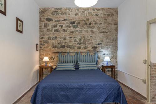 a bedroom with a bed with a brick wall at Agriturismo Spazzavento in Palazzone