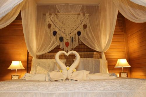 two swans made into hearts sitting on a bed at Green Village Jungle Resort in Nusa Penida