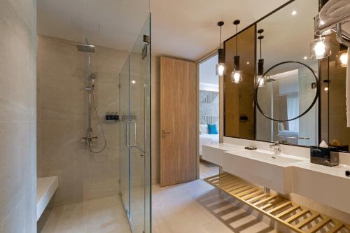 a bathroom with a shower and a sink and a mirror at The Nature Phuket - SHA Extra Plus in Patong Beach