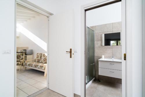 uma casa de banho com um lavatório e um espelho em Domo Bonaeras em Irgoli