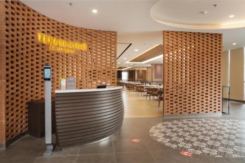 a lobby of a restaurant with a sign on a wall at Hotel Metland Smara Kertajati in Majalengka