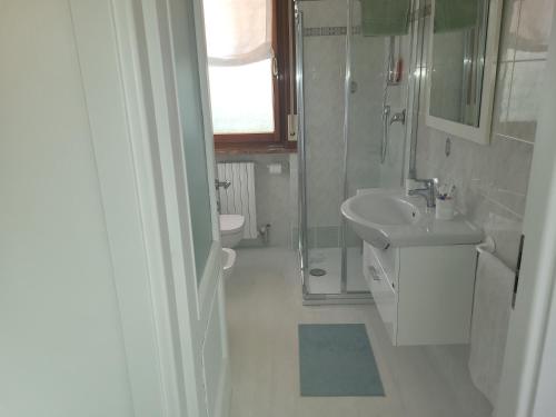 ein weißes Badezimmer mit einem Waschbecken und einem Spiegel in der Unterkunft A casa di Clo' in Sanremo