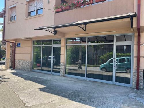 a store front with glass doors with a green van inside at Green Apartment in Strumica