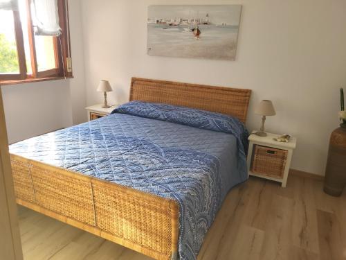 Schlafzimmer mit einem Bett mit blauer Decke in der Unterkunft A casa di Clo' in Sanremo