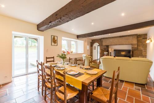 une salle à manger et un salon avec une table et des chaises dans l'établissement Gîte de Kerduraison - Maison avec grand jardin, à Ploumilliau