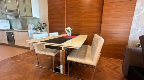a dining room table with chairs and a kitchen at Straits Quay Highest & Spacious Seaview Suite - 2 in Tanjong Tokong