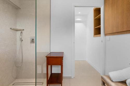a glass shower in a bathroom with a wooden table at Villa Nandina in Trans-en-Provence