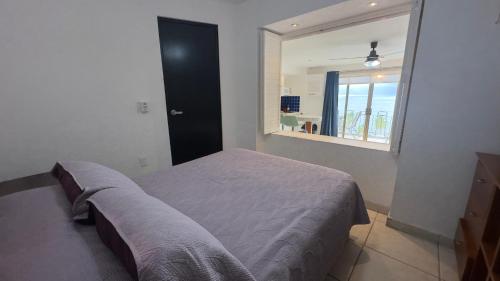 sypialnia z łóżkiem i dużym oknem w obiekcie Hermoso Condo Frente al Mar w mieście Puerto Vallarta