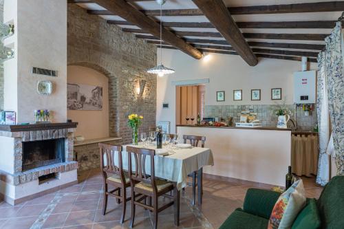 a kitchen and dining room with a table and a fireplace at Agriturismo Spazzavento in Palazzone