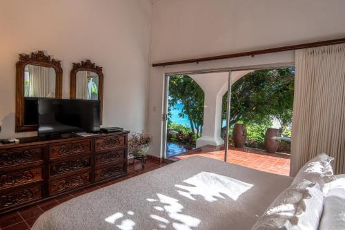 a bedroom with a bed and a tv and a window at Rancho Las Cruces in Las Cruces