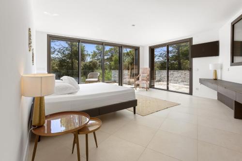 1 dormitorio con cama, mesa y algunas ventanas en Villa Valériane, en Trans-en-Provence
