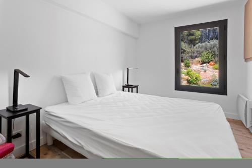 a white bed in a room with a window at Villa Nandina in Trans-en-Provence