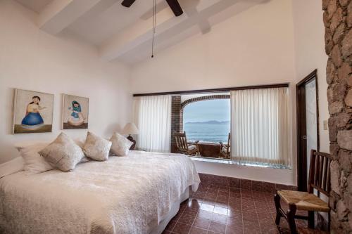 a bedroom with a bed and a view of the ocean at Rancho Las Cruces in Las Cruces