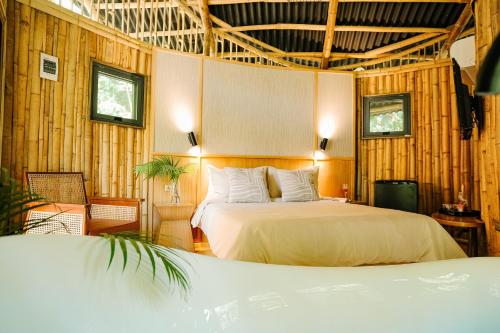 1 dormitorio con 1 cama en una habitación con paredes de madera en Treehouse de Valentine en Balamban