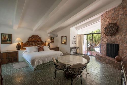 a bedroom with a bed and a table and a fireplace at Rancho Las Cruces in Las Cruces