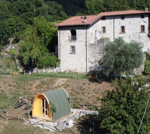 a building with a house in the middle of a field at Agriturismo Fattoria didattica Il Macereto in Fivizzano