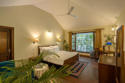 a bedroom with a bed and a desk and a window at Citrus County, Hoshiarpur, amã Stays & Trails in Hoshiārpur