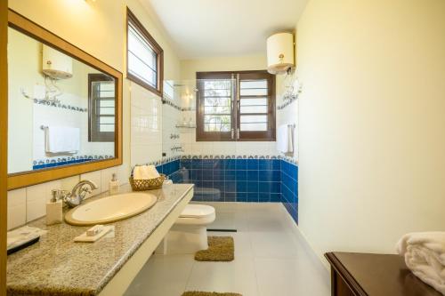 a bathroom with a sink and a toilet and a mirror at Citrus County, Hoshiarpur, amã Stays & Trails in Hoshiārpur