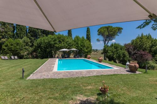 a swimming pool in a yard with an umbrella at Agriturismo Spazzavento in Palazzone