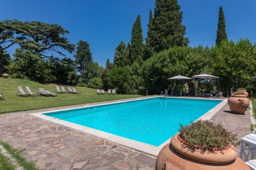a swimming pool in a yard with chairs and trees at Agriturismo Spazzavento in Palazzone