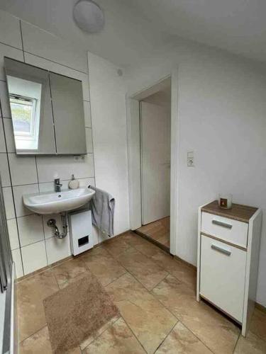 a white bathroom with a sink and a mirror at Gemütliche Stadtoase in Weingarten