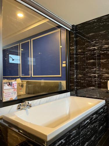 a bathroom with a white sink and a window at นั่งเล่นกันไหม รีสอร์ท SHA Plus in Chon Buri
