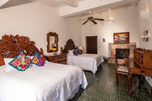 a bedroom with two beds and a desk and a piano at Rancho Las Cruces in Las Cruces