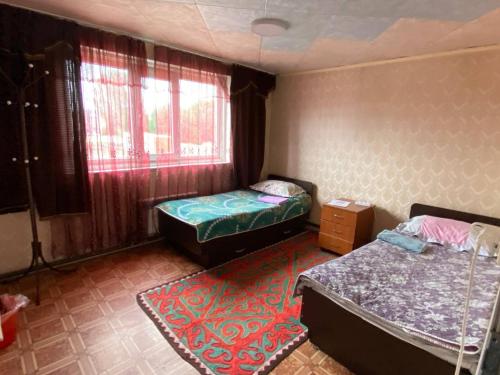 Cette petite chambre comprend 2 lits et une fenêtre. dans l'établissement Center guesthouse, à Kochkorka