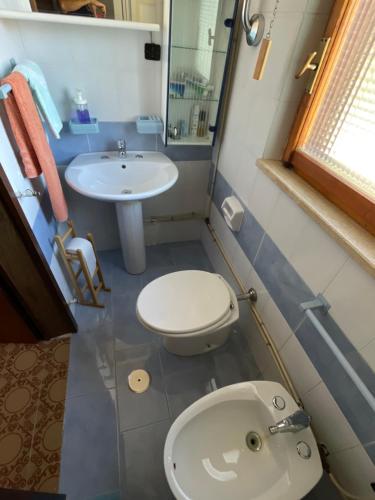 La petite salle de bains est pourvue de toilettes et d'un lavabo. dans l'établissement Villaggio Palumbo Sila - Appartamento, à Cotronei