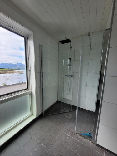 uma casa de banho com um chuveiro e uma janela em Moderne rorbu i Lofoten, Vestvågøy em Gravdal