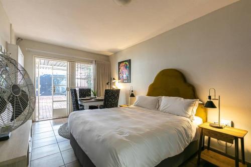 een slaapkamer met een groot bed en een tafel en stoelen bij Greenside entire place 48Mb Wi-Fi in Johannesburg
