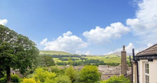 a view of a town with hills and trees at Middle House in Askrigg