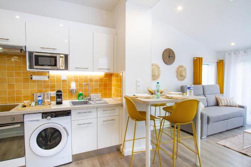 a kitchen with a washing machine and a table with chairs at Soleil d'Été - Netflix & Wifi - Balcon - Parking Gratuit - check-in 24H24 - GoodMarning in Châlons-en-Champagne
