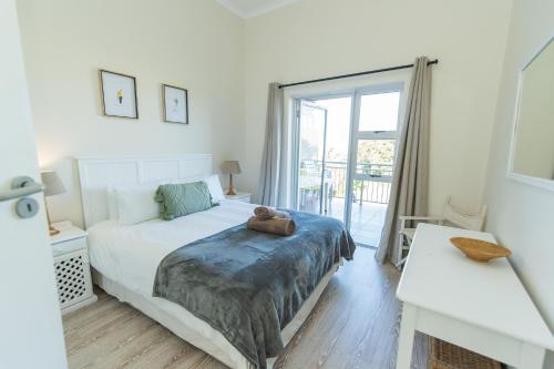 a bedroom with a bed with a teddy bear on it at P7 - Goose Valley - Ocean Views in Plettenberg Bay