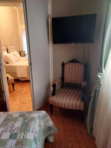 a bedroom with a bed and a chair in a room at Valia's house -Makri Village in Mákri