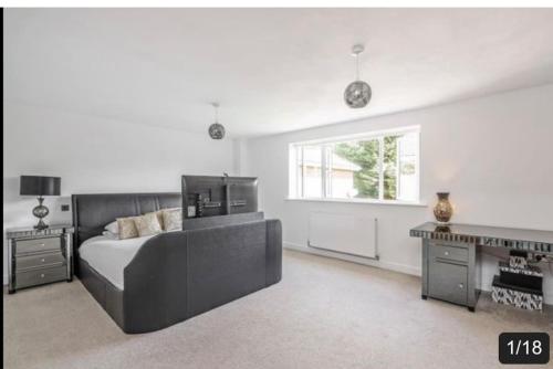 a bedroom with a bed and a desk and a window at The Fairways, St Bernard’s Road in Olton