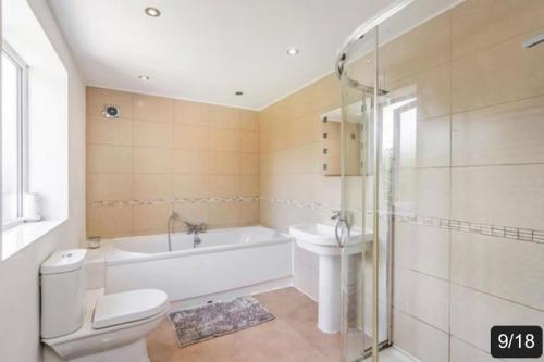 a bathroom with a tub and a toilet and a sink at The Fairways, St Bernard’s Road in Olton