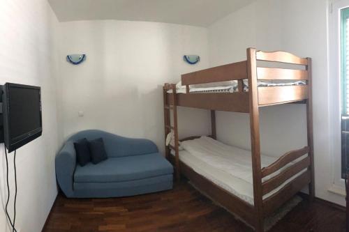 a room with two bunk beds and a chair at AC apartment in Okrug Gornji