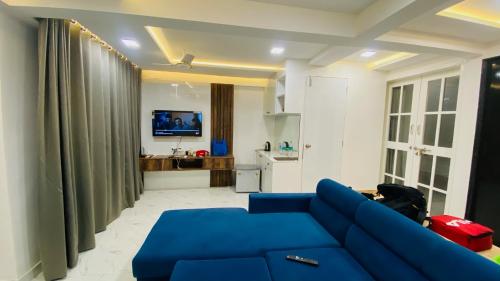 a living room with a blue couch and a tv at NIRAKI by Seascapes in Harnai