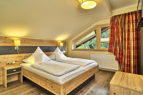 a bedroom with two beds and a window at Hotel Das Bayerwald in Lam