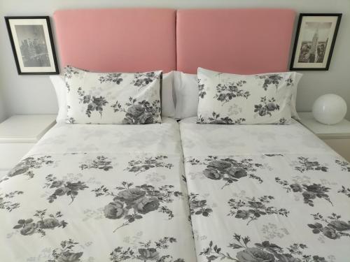 a bed with a black and white comforter and pillows at Apartamento Virgen del Carmen in Santoña