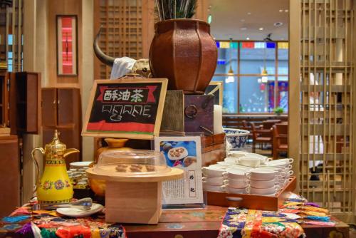 a table with dishes and a sign on top of it at Hilton Jiuzhaigou Resort in Jiuzhaigou