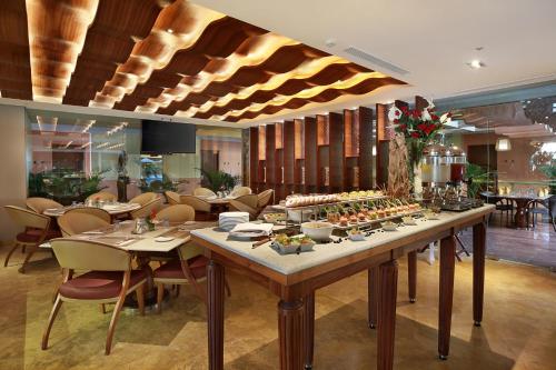 a restaurant with a long table with food on it at SenS Hotel and Spa in Ubud