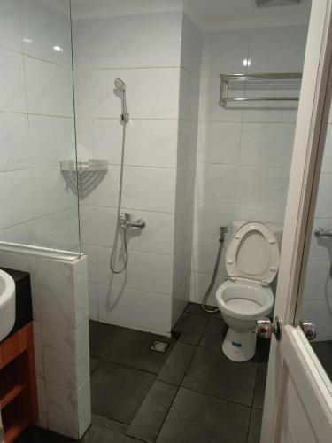 a bathroom with a shower and a toilet and a sink at Yukari Seturan Yogyakarta at Altuz Apartment in Seturan