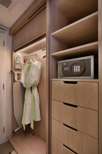 a walk in closet with a microwave and a tv at SenS Hotel and Spa in Ubud