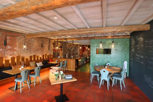 ein Restaurant mit Tischen, Stühlen und einer Tafel in der Unterkunft Müller! Das Weingut & Weinhotel in Hammelburg